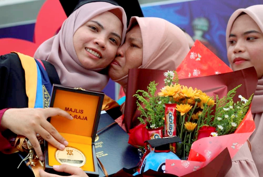SITI Aliza (tengah) mencium anaknya, Siti Madihah yang menerima Anugerah Pelajaran Diraja. FOTO Nor Amalina Alias