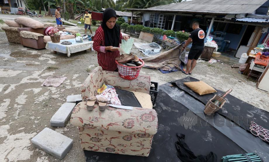 Penduduk membersihkan kawasan rumah yang terjejas akibat banjir di Gelang Patah. FOTO Mohd Azren Jamaludin