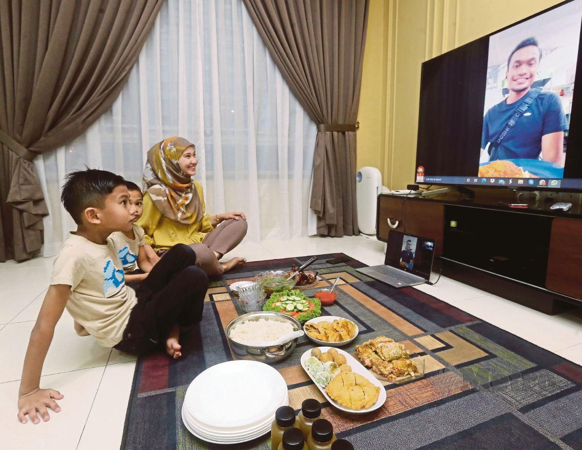 Nor Fazilah Deris, 33,  ditemani anaknya  Muhammad Danish Anaqi , 8, dan Muhammad Dinie Asyraf, 6, membuat panggilan video dari Senai, Johor bersama suaminya Muhammad Razi Abdul Ghani, 34, yang berada di Singapura ketika waktu berbuka puasa bersama-sama pada 2 Mei. FOTO Nur Aisyah Mazalan