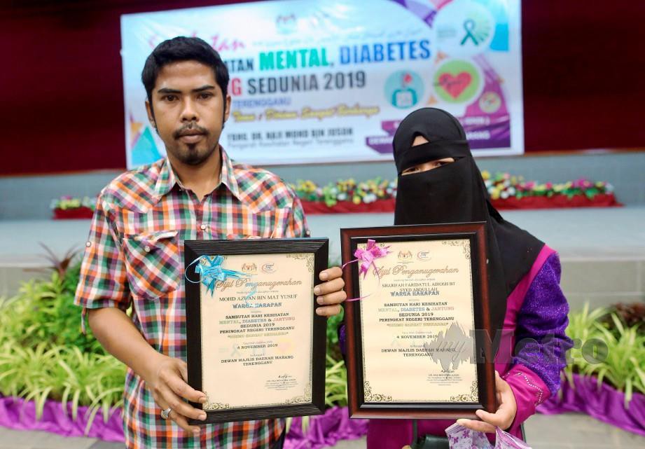 Mohd Azuan (kiri) dan Sharifah Faridahtul Atrosh menerima sijil penghargaan sebagai Warga Harapan hari ini. FOTO Ghazali Kori