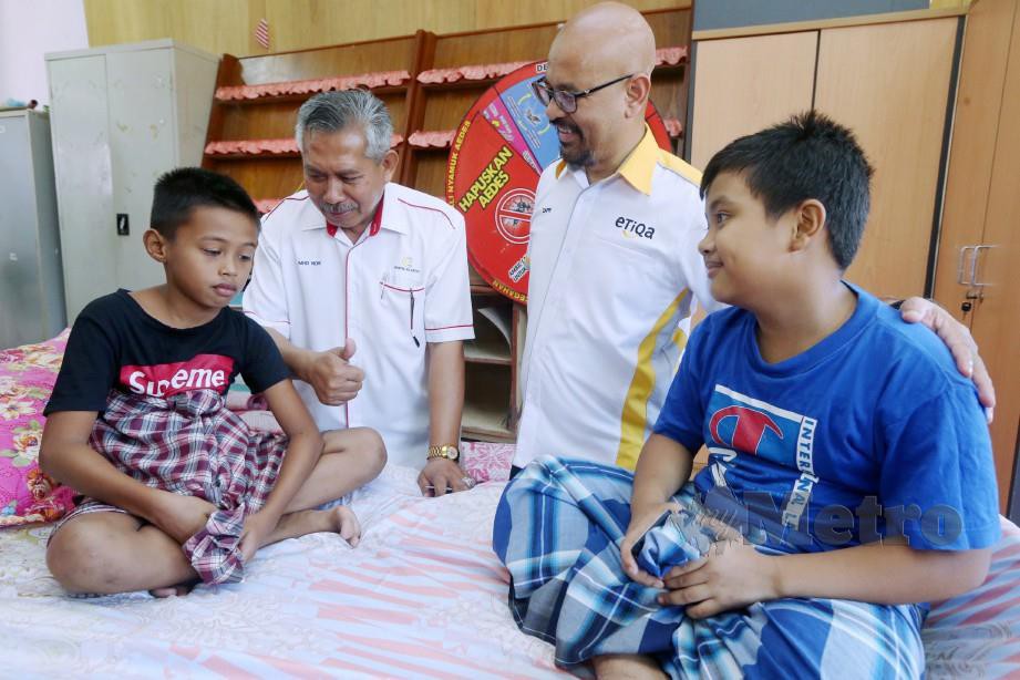 ZAFRI (dua kanan) dan Mhd Nor (tiga kiri) bersama Mohamad Amin Mohd Ros, 10, (kanan) dan Mohamad Hakim Hakimui Mohd Irwan, 10, yang menyertai Program Khatan Perdana Siri 1/2019. FOTO Zaman Huri Isa