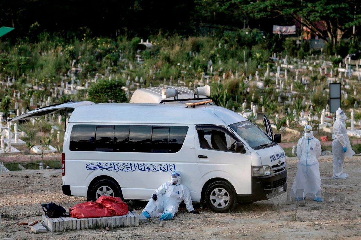 Petugas kesihatan keletihan selepas melakukan pengebumian seorang pesakit Covid-19 di Tanah Perkuburan Islam Kampung Sungai Pusu, Gombak, pada 22 Mei.FOTO Aizuddin Saad