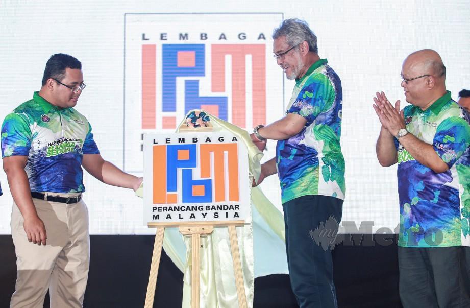 KHALID (dua kanan) dan Amirudin (kiri) serta Mohd Anuar ketika perasmian logo baharu Lembaga Perancangan Bandar Malaysia, hari ini. FOTO Sairien Nafis.
