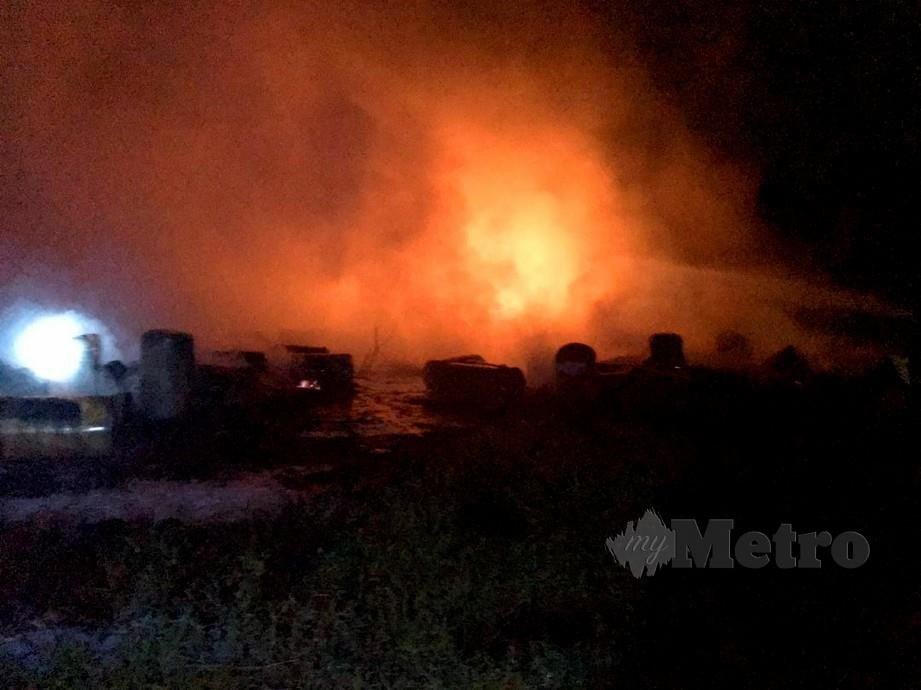 ANGGOTA bomba berusaha memadamkan kebakaran longgokan tong bahan kimia di kawasan lapang di Kampung Tambak Jawa. FOTO ihsan Bomba