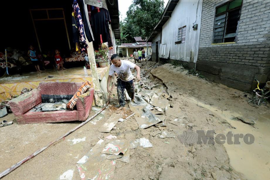 Penduduk mencuci rumah selepas banjir melanda Kampung Chuchoh Puteri, Ahad lalu. FOTO Syamsi Suhaimi