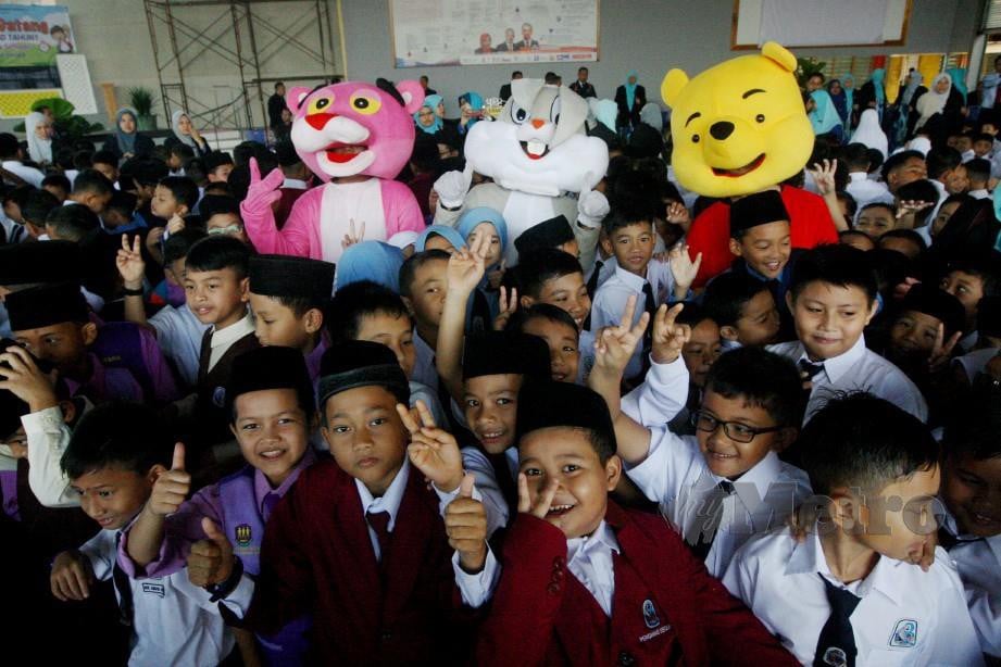 MASKOT watak Pooh, Bugs Bunny dan Pink Panther meraikan murid Tahun Satu pada hari pertama persekolahan. FOTO Zaman Huri Isa