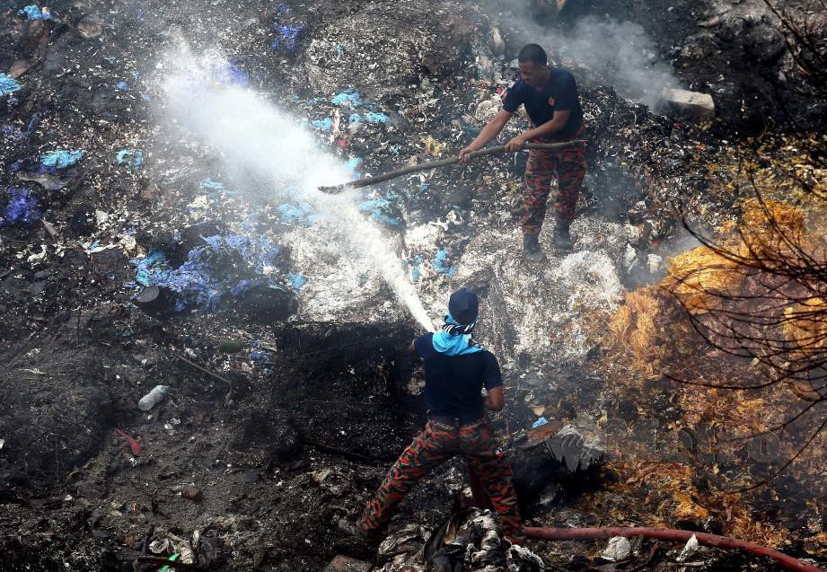 ANGGOTA bomba bertungkus lumus memadamkan kebakaran di tapak pelupusan sampah haram di Jalan Kuari off Jalan Iskandar, Kampung Bukit Kapar. Kebakaran dipercayai bermula dari jam 2 pagi semalam. FOTO Saddam Yusoff