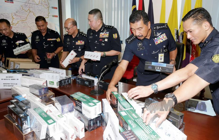 Ramli (dua dari kanan) menunjukkan pelbagai jenis rokok yang dirampas polis. FOTO Mohd Radzi Bujang