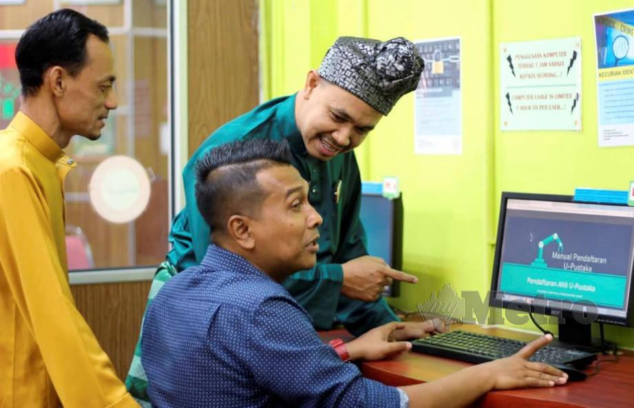 MOHD Azizi menunjukkan cara melayari perpustakaan digital. FOTO Nor Amalina Alias.