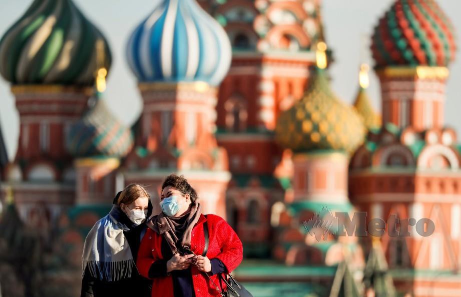 DUA wanita berjalan di Moscow pada 26 Mac lalu. FOTO Reuters