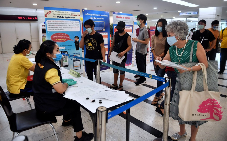 ORANG ramai beratur untuk memperbaharui visa di bangunan Imigresen di Bangkok. FOTO AFP.