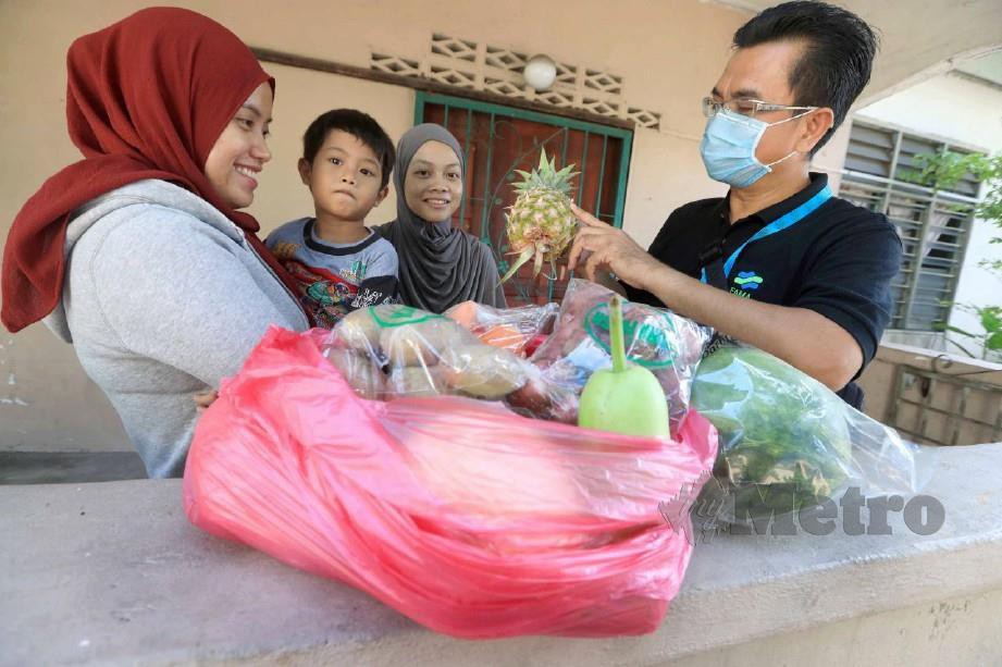 ROSLI menyampaikan bantuan buah dan sayur kepada Nur Aswareena. FOTO Mohd Rafi Mamat