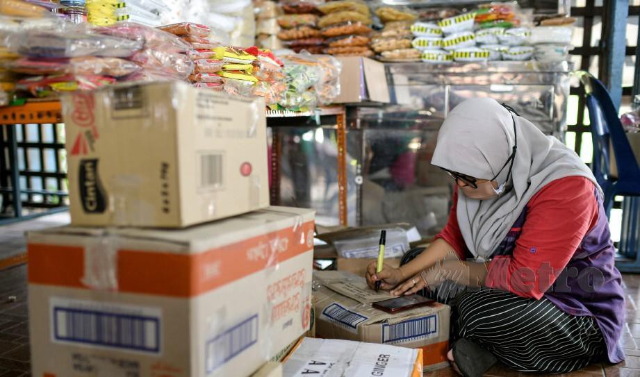 Pekerja perniagaan makanan tradisional, Rozalina Ramli, 30, sedang menyiapkan barangan tempahan pelanggan. FOTO Bernama