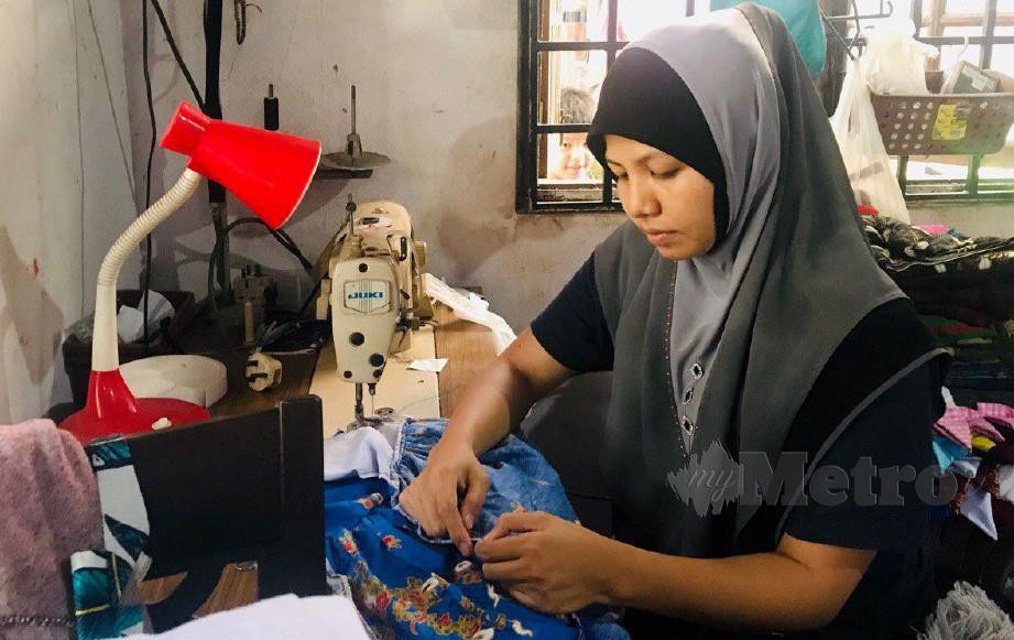 NOR Nadia menyiapkan tempahan baju raya pelanggannya. FOTO Hazira Ahmad Zaidi