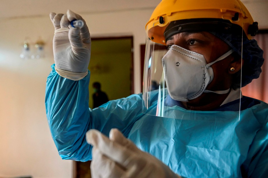 PEKERJA kesihatan memeriksa sampel ujian pesakit bagi Covid-19 di rumahnya di Colombian. FOTO AFP