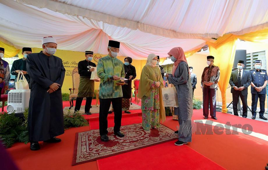 AL-SULTAN Abdullah (dua, kiri) dan Tunku Azizah berkenan menyampaikan sumbangan kepada anak-anak yatim Pertubuhan Rahoma Darul Fakir Malaysia. FOTO Bernama