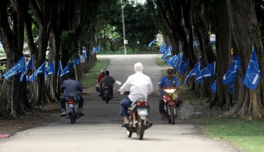 BENDERA parti yang bertanding memenuhi jalan utama di Felda Chini, ketika tempoh berkempen bagi  PRK Dun Chini. FOTO Farizul Hafiz Awang.