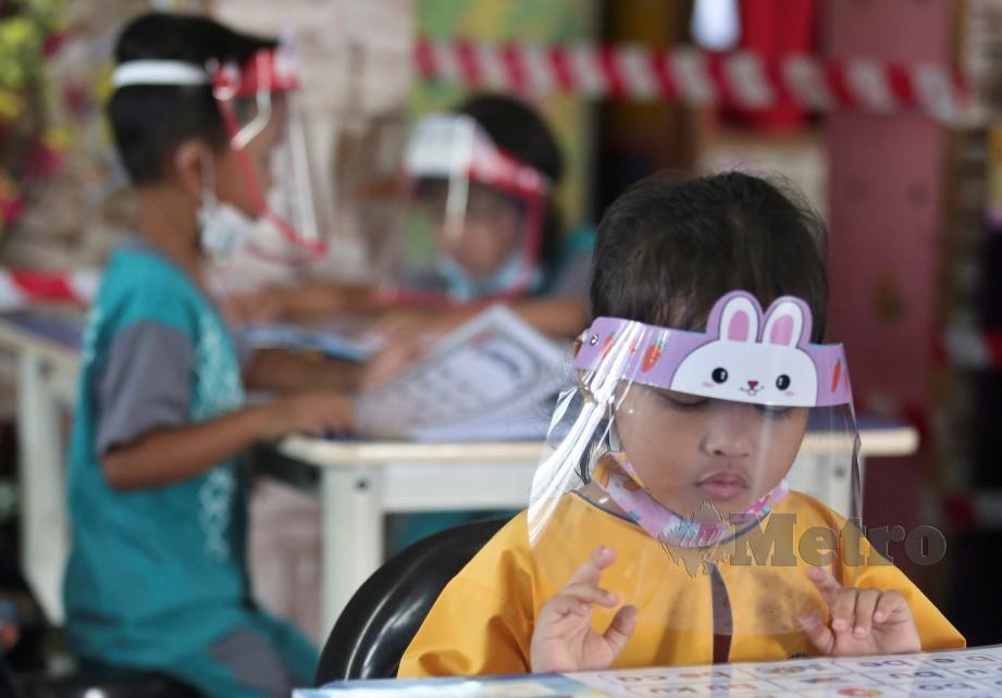 Murid di tabika di Kuala Terengganu memakai topeng pelindung muka ketika sesi pembelajaran hari pertama sesi persekolahan. FOTO GHAZALI KORI