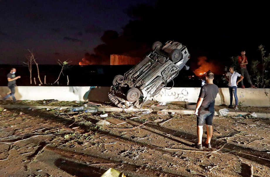 ORANG ramai melihat kereta yang musnah akibat letupan di pelabuhan di Beirut. FOTO AFP