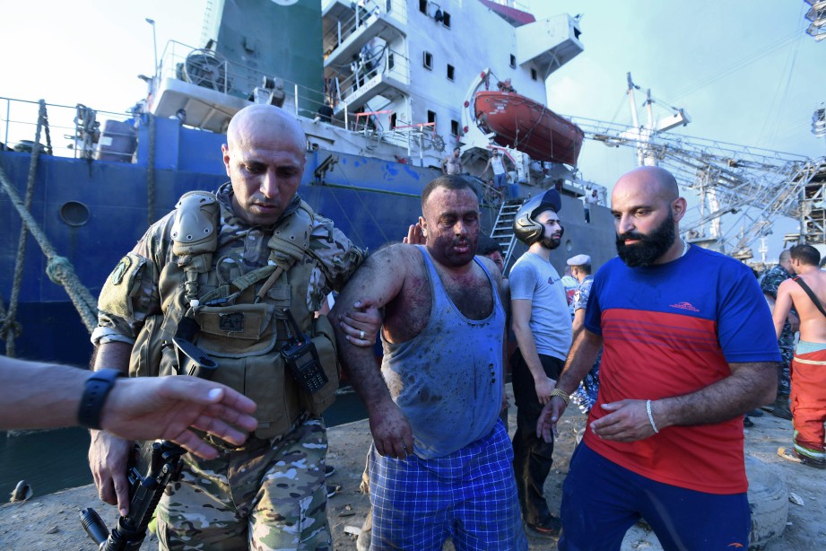 ANGGOTA tentera Lubnan membawa lelaki cedera dari kapal di pelabuhan Beirut, di mana berlakunya dua letupan. FOTO AFP