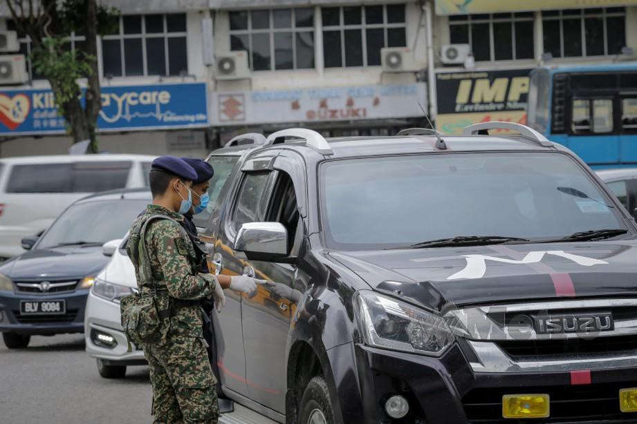 ANGGOTA polis dibantu anggota tentera memeriksa dokumen pergerakan di sekatan jalan raya Jalan Batu Unjur 10 selepas PKPB dilaksanakan di kawasan tersebut. FOTO Asyraf Hamzah