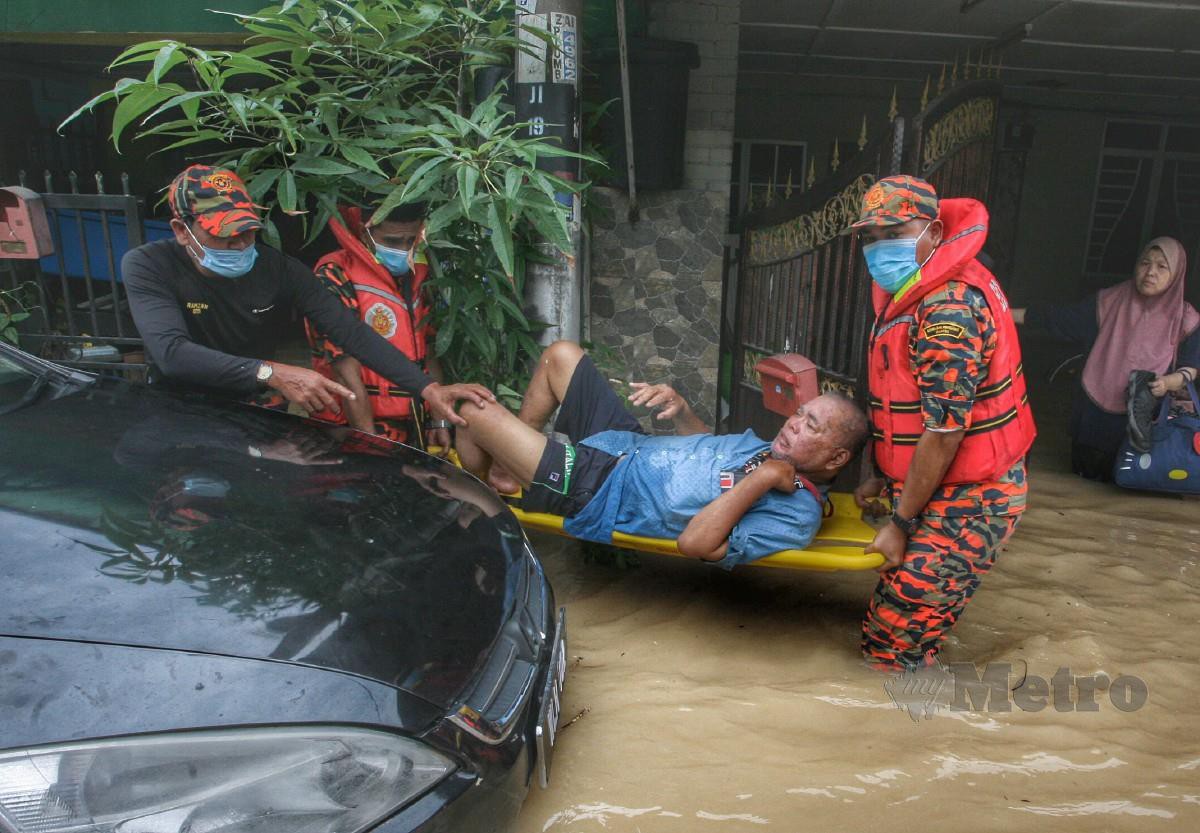 ANGGOTA Bomba dan Penyelamat dibantu penduduk menyelamatkan mangsa banjir di Taman Sri Nanding. FOTO Mohd Yusni Ariffin.