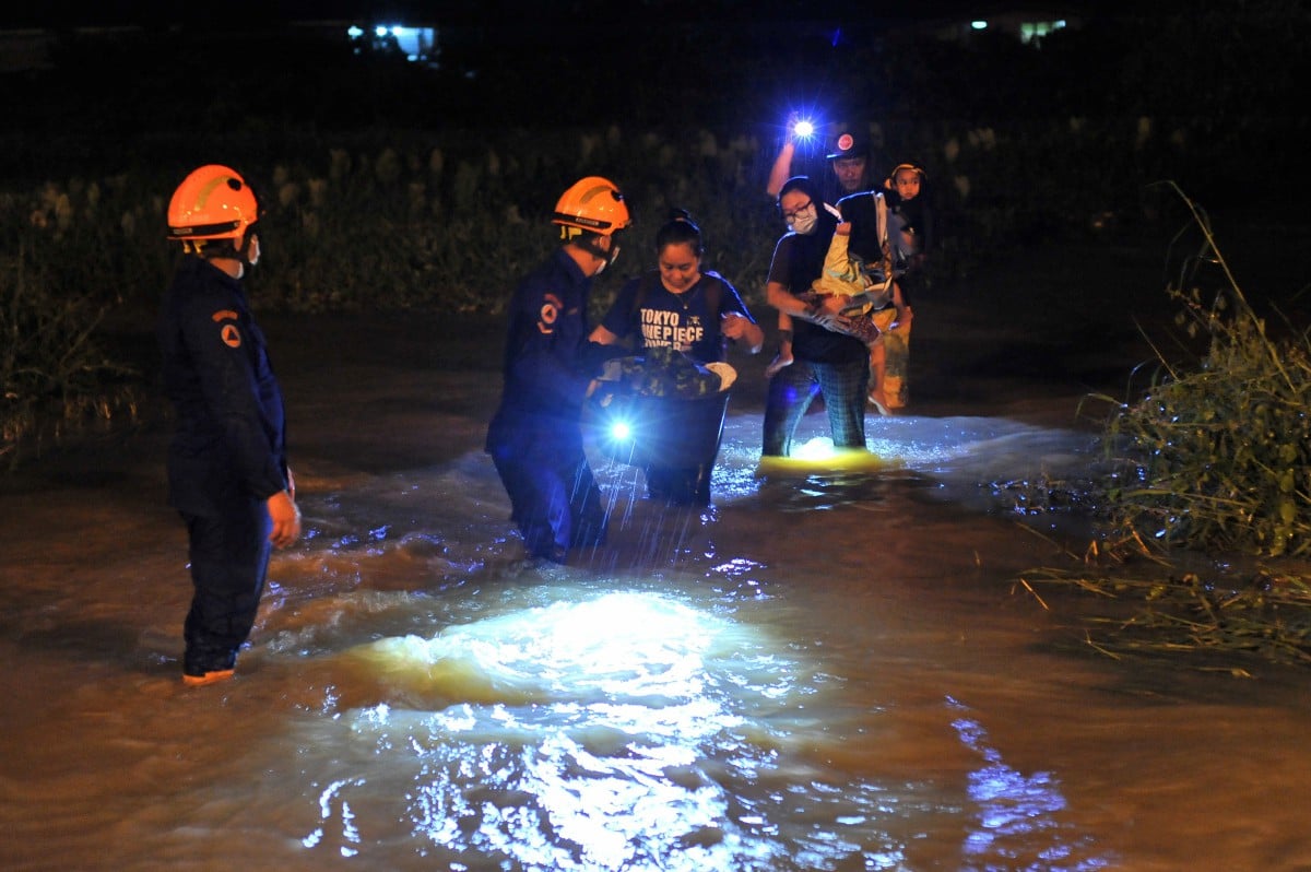 ANGGOTA Angkatan Pertahanan Awam Malaysia (APM) dan Jabatan Bomba dan Penyelamat Malaysia (JBPM) melakukan operasi menyelamat mangsa banjir di Kampung Ganggarak, Labuan. FOTO BERNAMA
