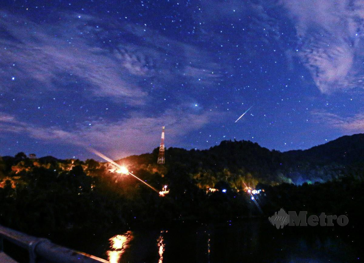 KELIHATAN meteor Geminid melintasi ruang udara kawasan Kampung Orang Asli Pertak, Kuala Kubu Baharu. FOTO Osman Adnan