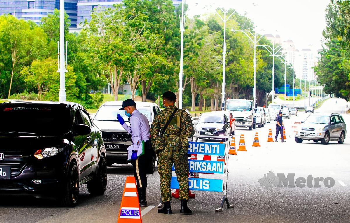 ANGGOTA polis dan ATM melakukan sekatan jalan raya (SJR) di Putrajaya berikutan pelaksanaan semula Perintah Kawalan Pergerakan. FOTO Luqman Hakim Zubir