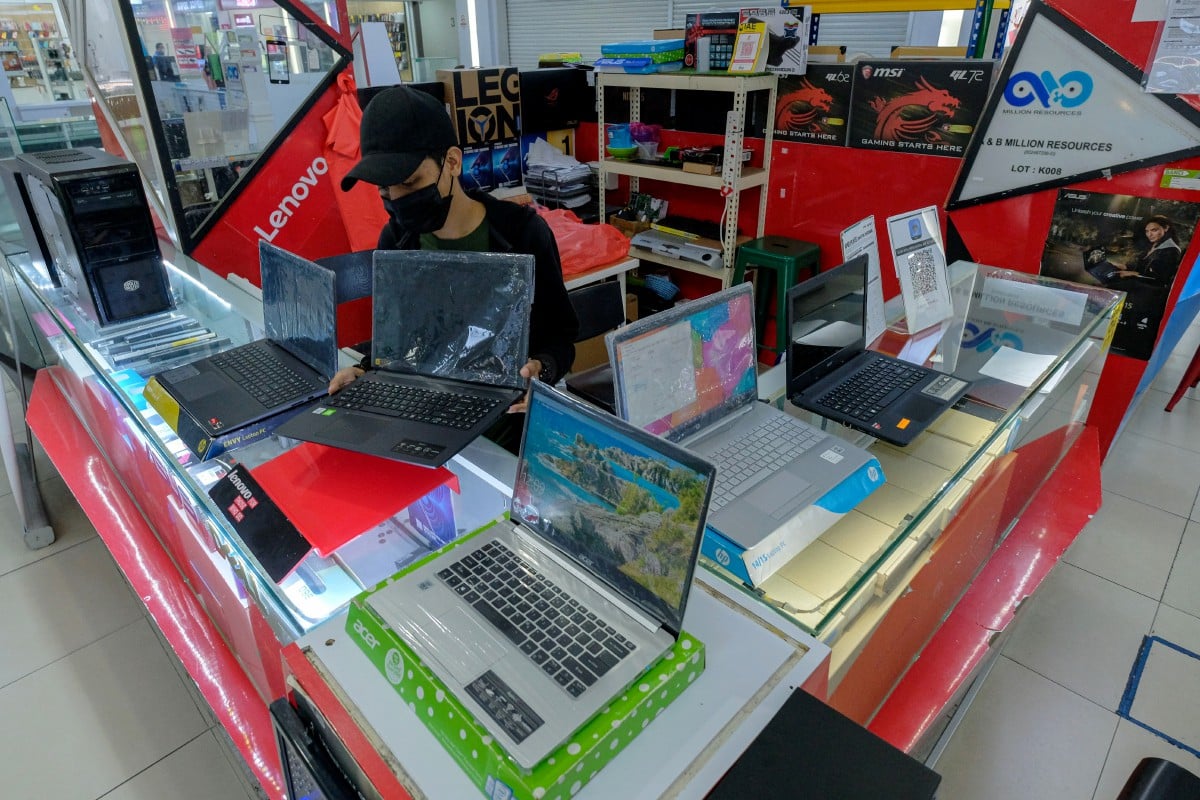 PEKERJA kedai komputer  mempamerkan pelbagai jenis komputer riba di Mara Digital Mall, 23 Jan lalu. FOTO Bernama