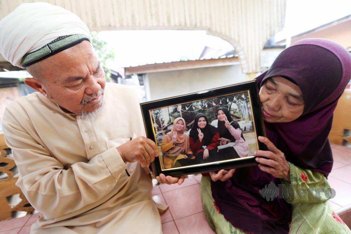 MOHD Nadzir (kiri) bersama isterinya, Zainun melihat gambar Nurul Syazwani, Sakinah dan Noor Fathiah, Mac lalu. FOTO arkib NSTP