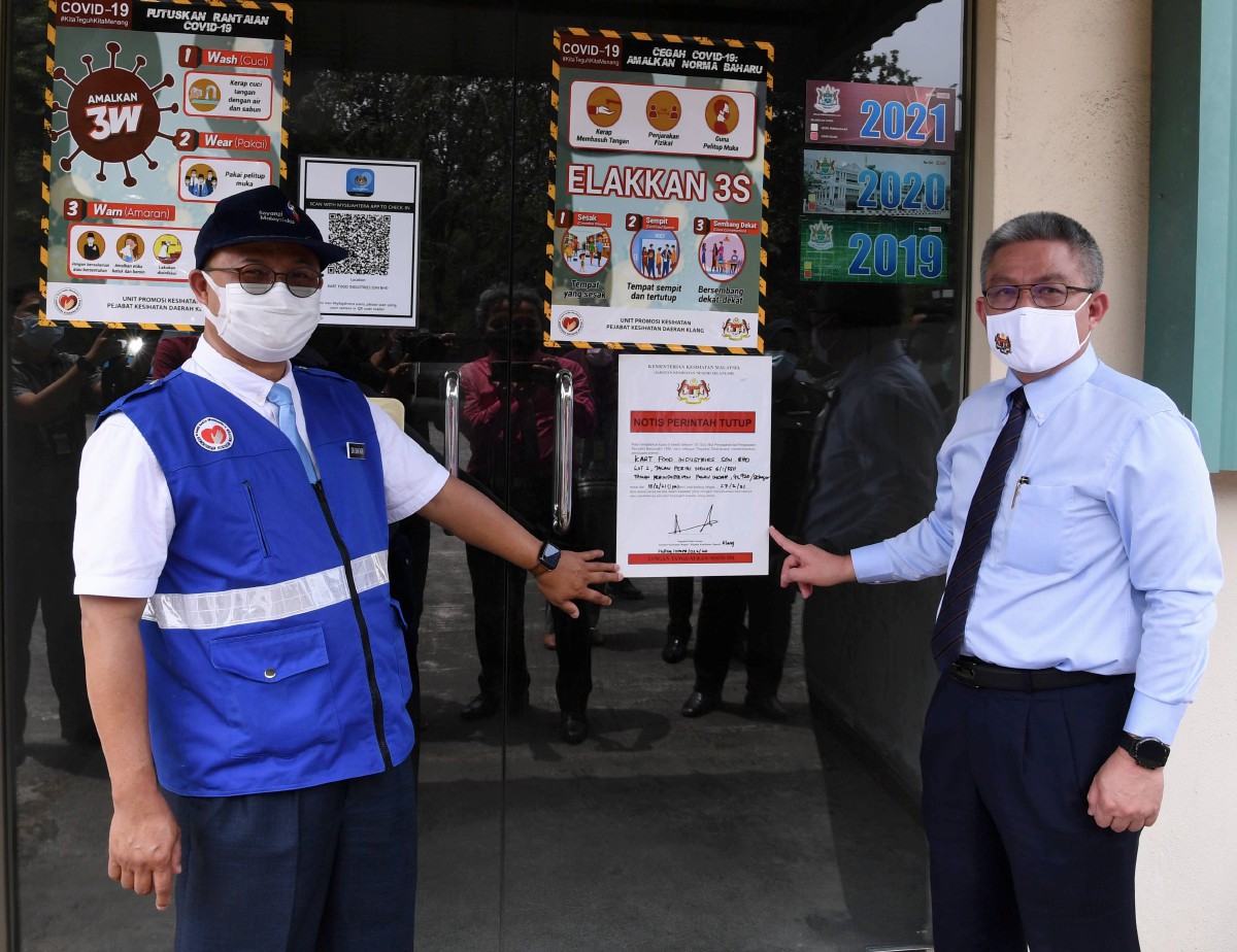 DR Adham (kanan) menunjukkan notis perintah tutup sementara berikutan penularan Covid-19 pekerja premis tersebut di Pulau Indah. Turut hadir Pengarah Kesihatan Negeri Selangor Datuk Dr Shaari Ngadiman (kiri). FOTO Bernama