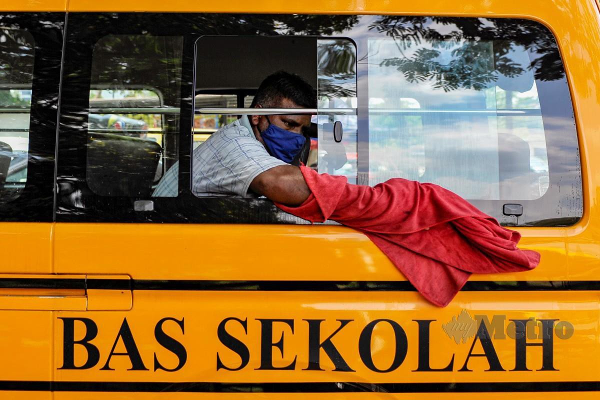 Pencuci kereta di Pantai Dalam, Kuala Lumpur mencuci bas sekolah sebagai langkah persediaan pembukaan sesi persekolahan secara bersemuka secara berperingkat bermula pada 1 Mac 2021. FOTO AIZUDDIN SAAD