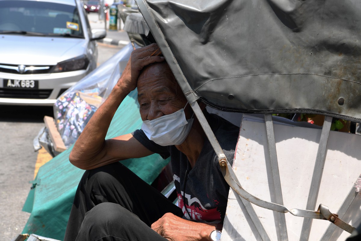 Pengayuh beca, Tan Kang, 71, menunggu pelanggan di perhentian beca di Jalan Penang. FOTO BERNAMA