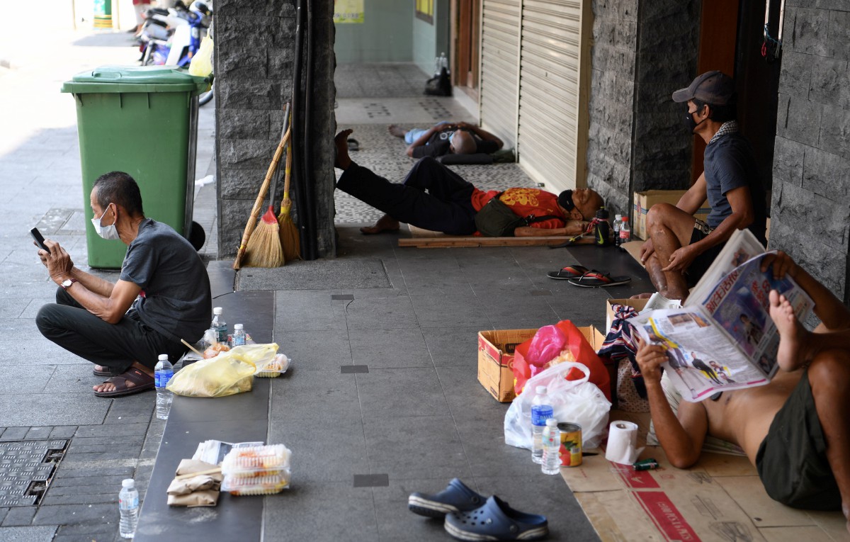 Beberapa pengayuh beca berehat di kaki lima di Jalan Penang sambil menunggu pelanggan. FOTO BERNAMA