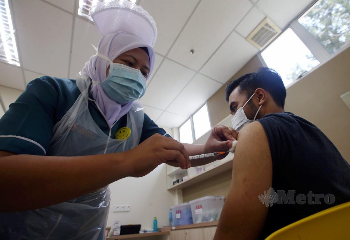 KAKITANGAN Hospital Lam Wah Ee (HLWE) memberi suntikan dos kedua vaksin jenis Pfizer-BioNTech kepada seorang petugas hospital berkenaan di Pusat Vaksinasi Covid-19 HLWE, Jelutong. FOTO Danial Saad