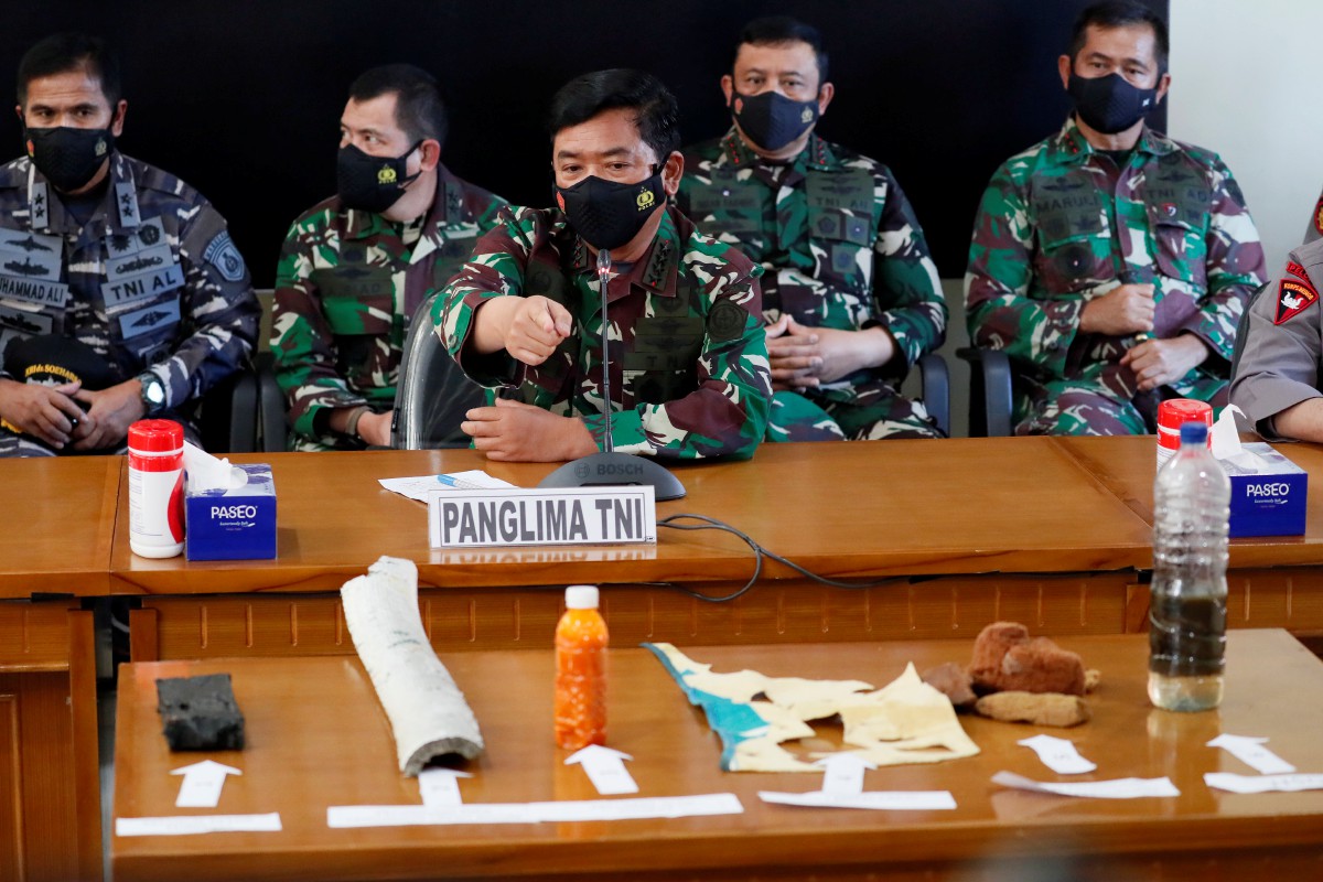 KETUA angkatan tentera Hadi Tjahjanto (tengah) mempamerkan serpihan dipercayai daripada KRI Nanggala ketika sidang media. FOTO EPA