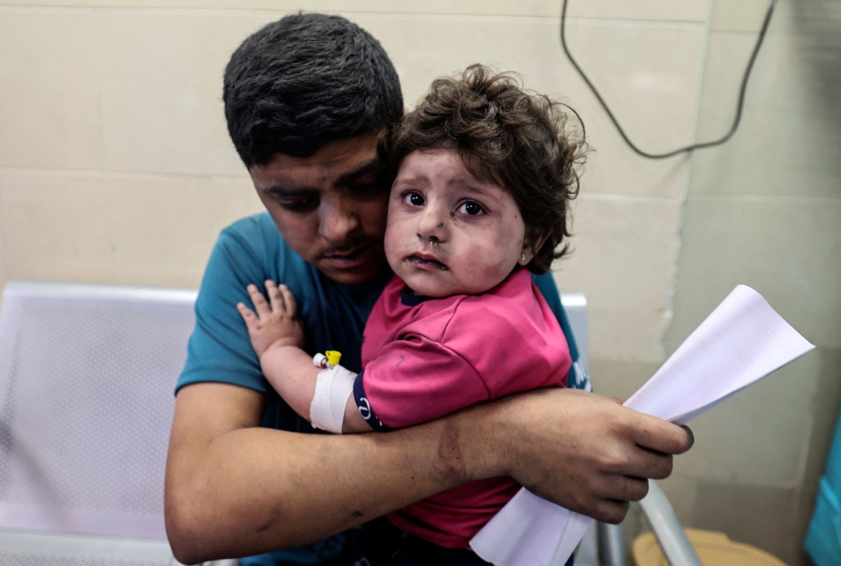 LELAKI Palestin bersama kanak-kanak perempuan yang cedera meninggu mendapat rawatan di hospital al-Shifa selepas serangan Israel di Gaza, semalam. FOTO AFP