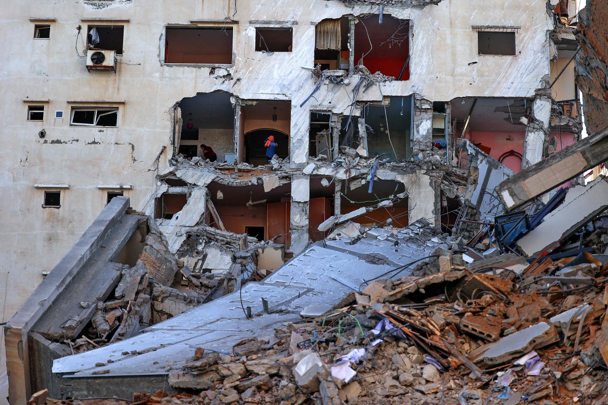 WANITA Palestin memeriksa kerosakan apartment di Gaza selepas serangan udara Israel. FOTO AFP