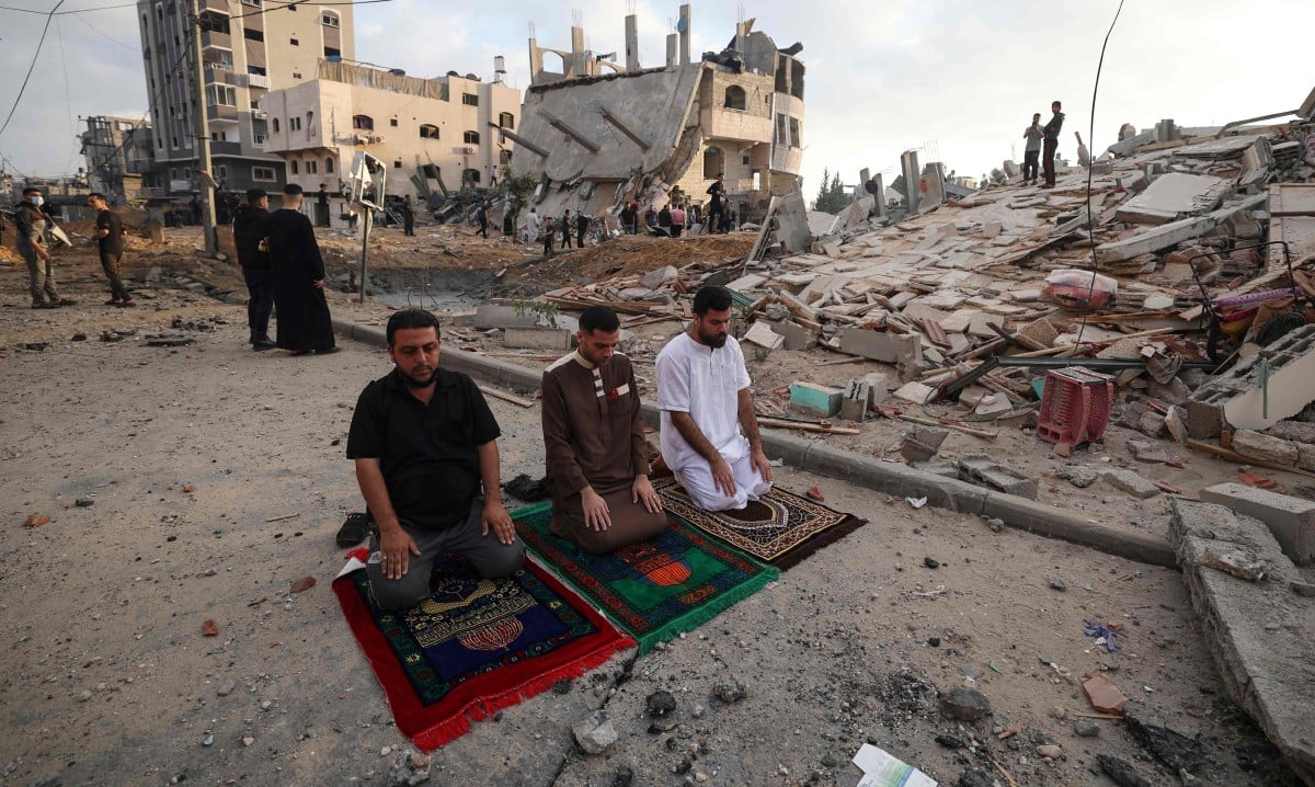 PENDUDUK Palestin menjalankan solat Aidilfitri di perkarangan bangunan runtuh. FOTO AFP