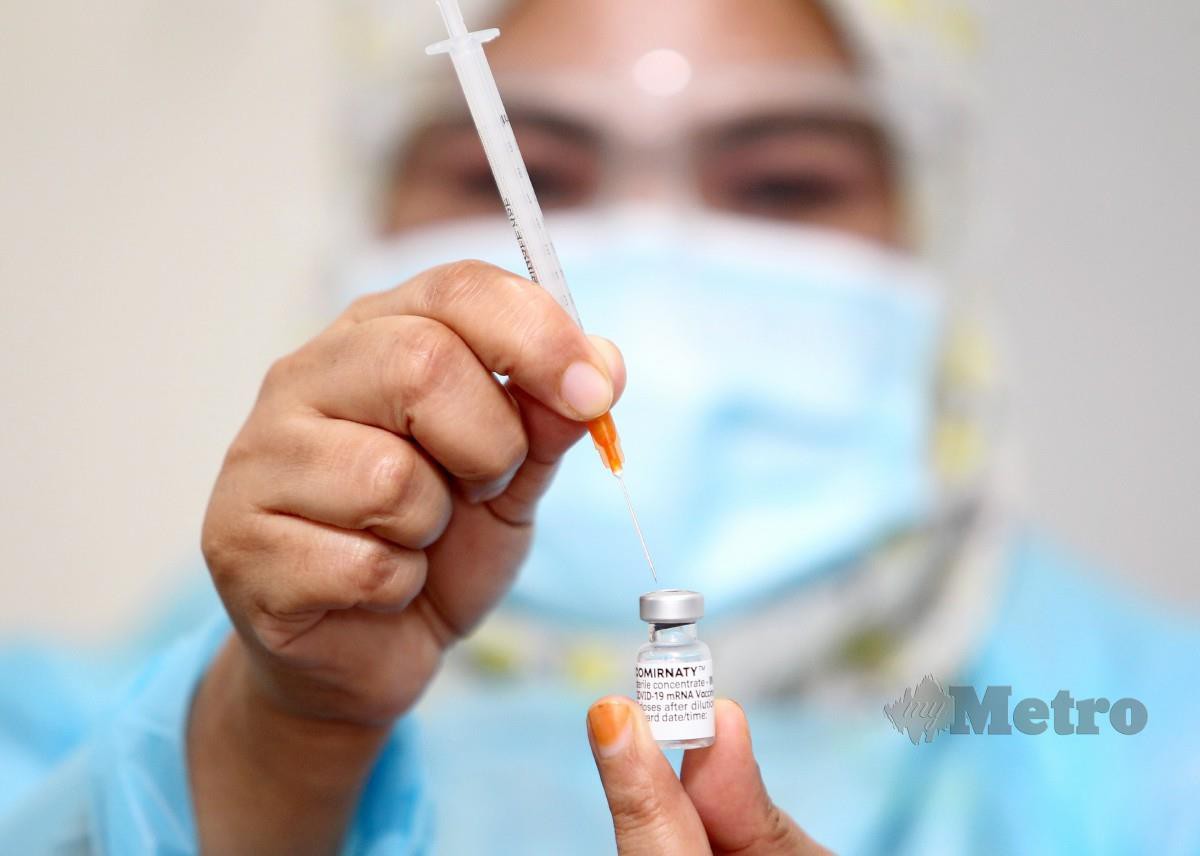 PETUGAS kesihatan menyediakan vaksin Covid-19 Pfizer-BioNTech di PPV di Tumpat, kelmarin. FOTO Nik Abdullah Nik Omar