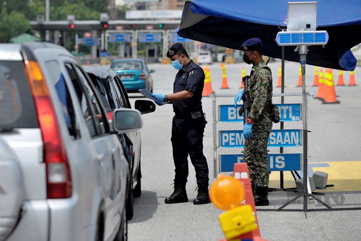 ANGGOTA polis bersama anggota ATM membuat pemeriksaan setiap kenderaan yang melepasi Sekatan Jalan Raya (SJR) berhampiran Plaza Tol Sungai Besi, Kuala Lumpur. FOTO Aizuddin Saad