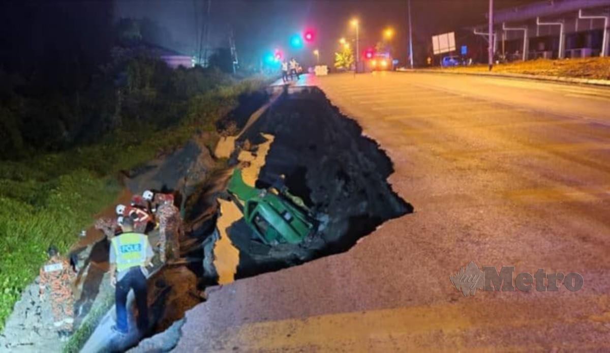 TANAH runtuh di tebing Jalan Kota Sentosa-Bau mengorbankan seorang pemandu van. FOTO ihsan Bomba