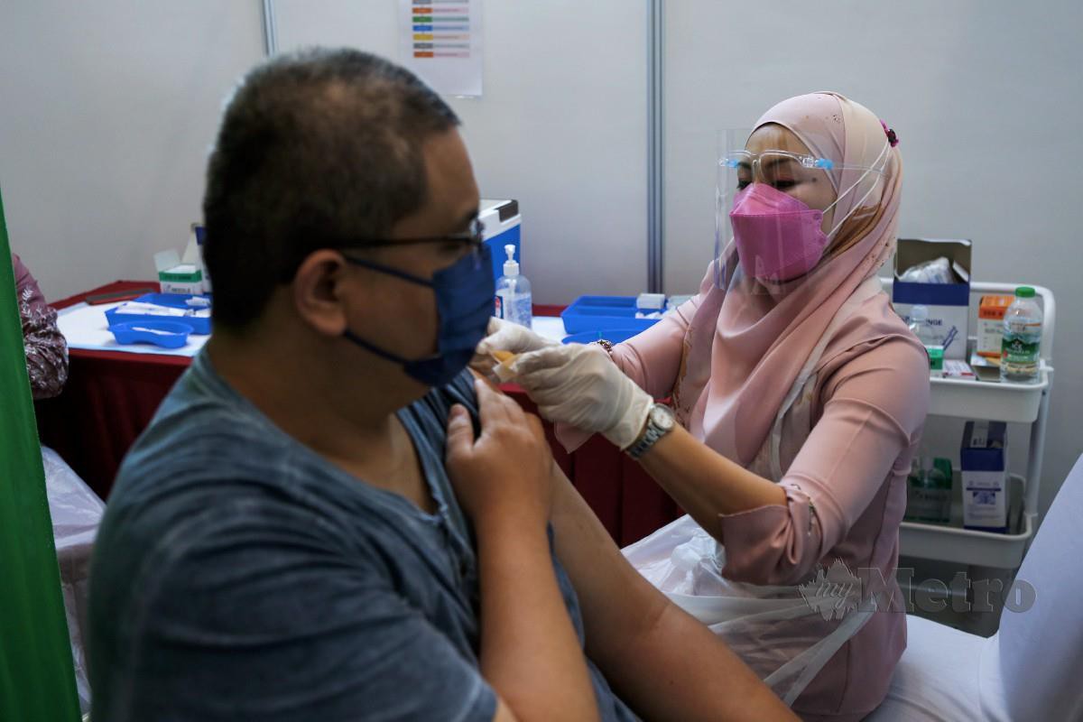 PETUGAS kesihatan, Roslinda Awang memberi suntikan vaksin kepada penerima di Bangi Avenue Convetion Center, semalam. FOTO Hazreen Mohamad