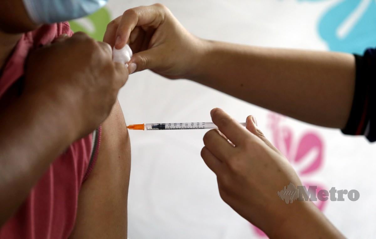 PETUGAS kesihatan memberi suntikan vaksin Covid-19 di Stadium Bandaraya Pulau Pinang di Georgetown. FOTO Mikail Ong