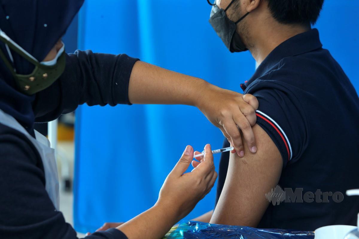 PETUGAS kesihatan memberi suntikan vaksin di Pusat Pemberian Vaksin (PPV) Integrasi di Dewan Serbaguna Encore, Melaka, semalam. FOTO Syafeeq Ahmad
