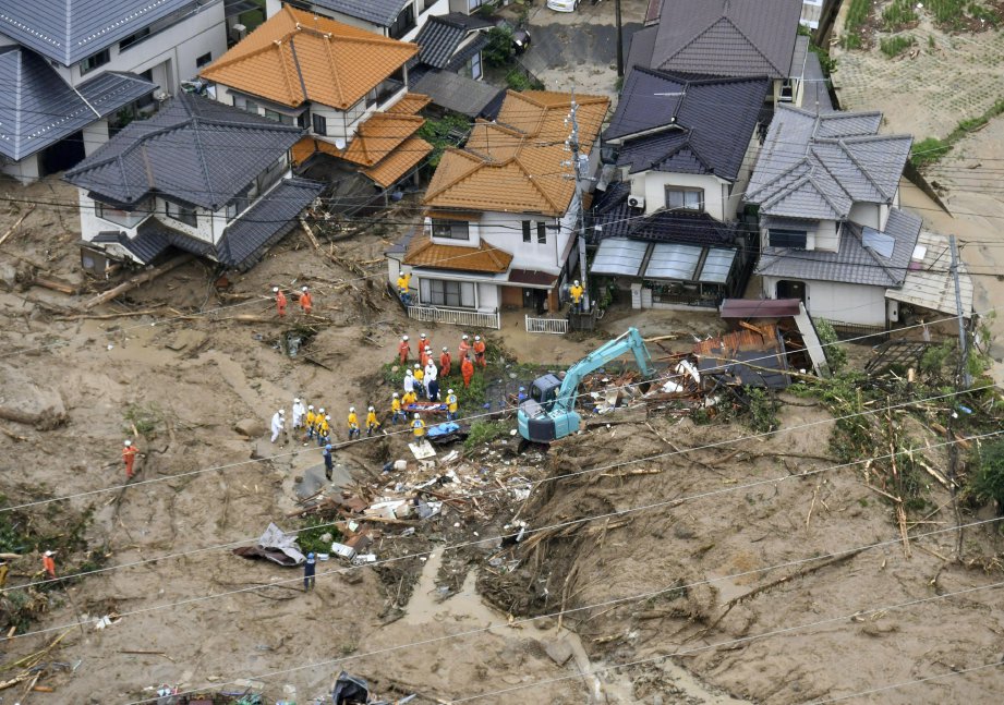 ANGGOTA penyelamat di kawasan rumah yang rosak akibat tanah runtuh berikutan hujan lebat di Hiroshimapada 7 Julai 2018. FOTO  Kyodo/Reuters