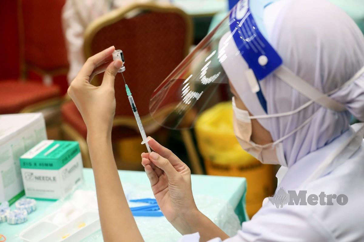 PETUGAS pejabat Kesihatan Daerah Petaling Jaya memasuki vaksin ke dalam picagari sebelum disuntik pada pelajar pada PICK Remaja di PPV Dewan Canselor MSU, Shah Alam. FOTO Owee Ah Chun