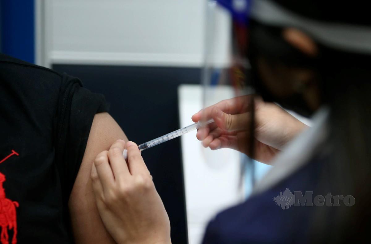 PETUGAS kesihatan memberikan suntikan vaksin Covid-19 di Pusat Pemberian Vaksin (PPV) Pusat Latihan UEM Edgenta, Petaling Jaya, semalam. FOTO Mohamad Shahril Badri Saali