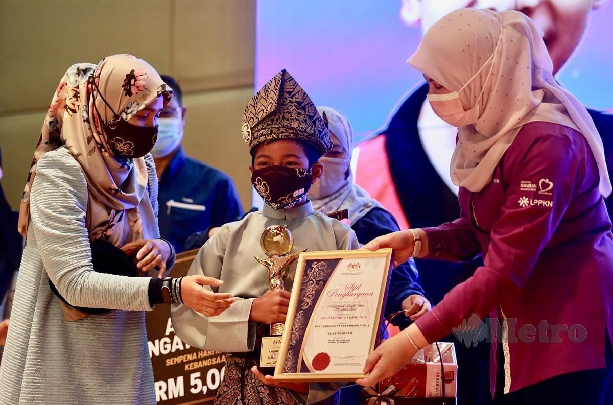 Rina (kanan) menyampaikan Anugerah Pingat Hang Tuah kepada Muhammad Hadif. FOTO Fathil Asri